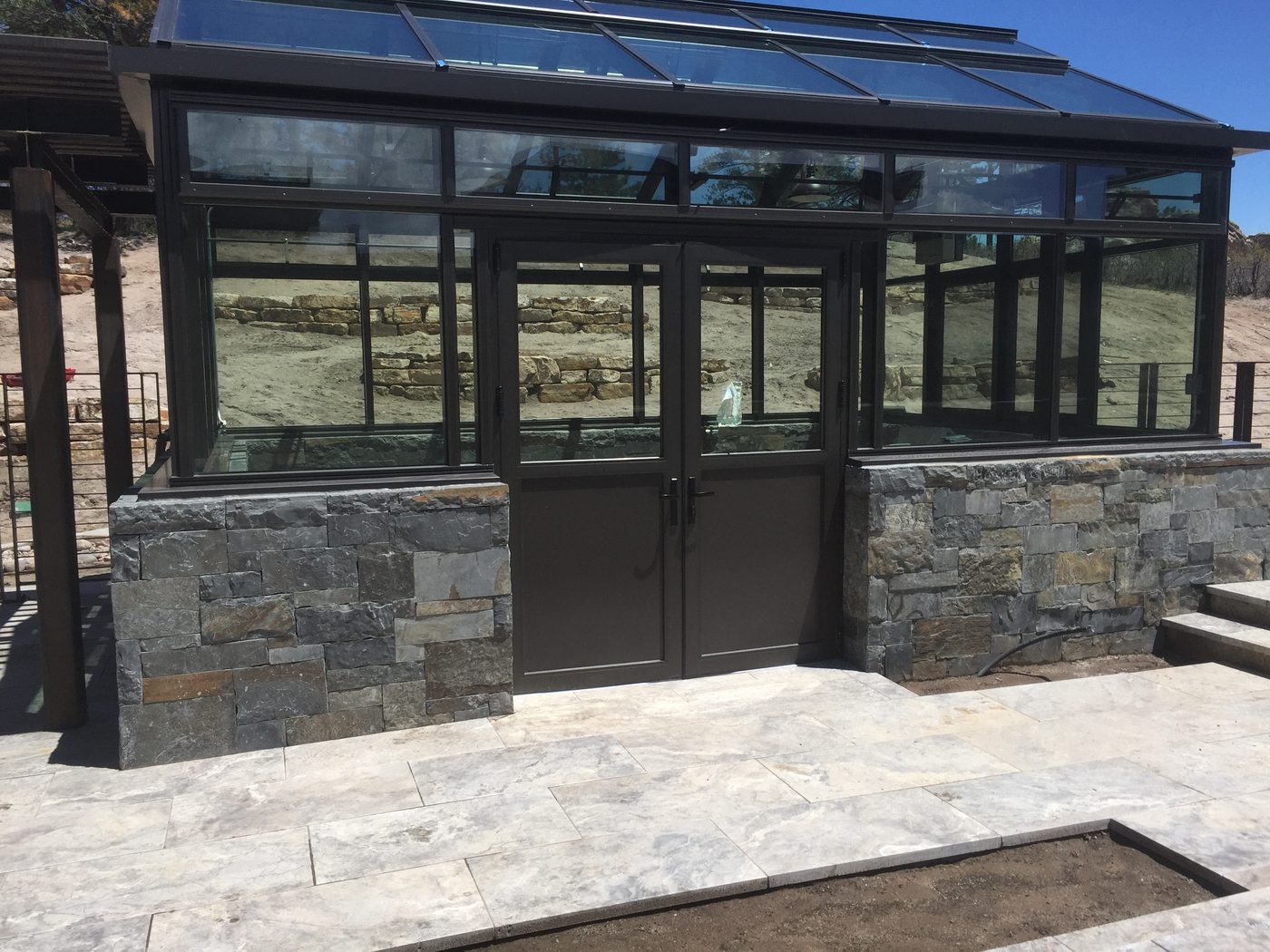 Stone-base conservatory with travertine patio
